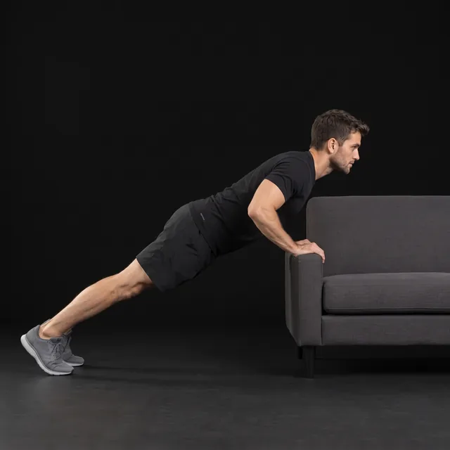 A person doing incline push-ups (hands on couch)